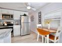 Bright kitchen featuring white cabinetry, stainless steel appliances, and a cozy dining area with a view at 662 Sinclair Cir, Tavares, FL 32778