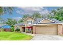 Inviting two-story home with manicured lawn, neutral color palette, and covered front porch seating area at 848 Bucksaw Pl, Longwood, FL 32750