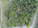 Overhead aerial view of a home nestled among trees and close to a road at 1050 Bob White Trl, Chuluota, FL 32766