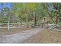 Long gravel driveway leading to a gated property with mature trees at 1050 Bob White Trl, Chuluota, FL 32766