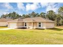 Inviting single-story home featuring a well-maintained lawn and an attached garage at 12 Pecan Drive Loop, Ocala, FL 34472