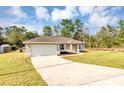 Attractive single-story home with attached two-car garage and long driveway at 12 Pecan Drive Loop, Ocala, FL 34472