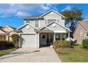 Charming two-story home with light grey siding, well-manicured lawn, covered porch, and attached garage at 1416 Creekside Cir, Winter Springs, FL 32708