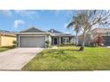 Charming single-story home with a well-manicured lawn and attached garage, complemented by lush landscaping at 2783 Trommel Way, Sanford, FL 32771