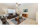 Living room with tiled floors, brown couches, and a coffee table at 3071 Beach Palm Ave, Kissimmee, FL 34747