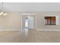 Bright and airy living room showcasing new wood-look tile, neutral paint and decorative light fixture at 605 Marni Dr, Winter Springs, FL 32708