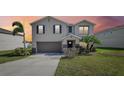 Charming two-story home with a well-manicured lawn and neutral stucco exterior under a colorful sunset at 11434 Wishing Well Ln, Clermont, FL 34711