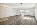 Open living room area showcasing updated flooring and a staircase to the second floor at 11434 Wishing Well Ln, Clermont, FL 34711