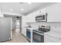 Modern kitchen boasts stainless steel appliances and white cabinetry at 1211 Dorothy St, Lakeland, FL 33815