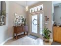 Bright entryway featuring tiled floor, cabinet, stylish lighting, and decorative wall art at 12918 Hunters Vista Blvd, Orlando, FL 32837