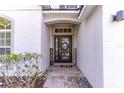 Close up of the front door with stone walkway and decorative shrubbery and 'Welcome' sign at 12918 Hunters Vista Blvd, Orlando, FL 32837