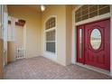 The main entrance has a red, double door with a brick-covered porch and an arched window above at 1332 Hunterman Lane, Winter Garden, FL 34787