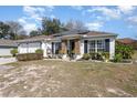 House exterior featuring a two-car garage and well-maintained landscaping at 1523 Whooping Dr, Groveland, FL 34736