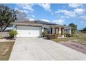 Front view of a house with a two-car garage and a brick walkway at 1523 Whooping Dr, Groveland, FL 34736