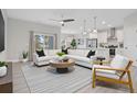 Bright, open-concept living room showcasing modern furnishings and seamless flow into the adjacent kitchen at 2011 Begonia Way, Poinciana, FL 34759
