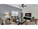 Living room featuring a sectional sofa, coffee table, and large TV at 3097 Pequod Pl, Kissimmee, FL 34746