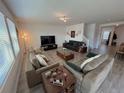 Open living room with ample seating, large TV, and light gray flooring at 4390 Bull St, St Cloud, FL 34772