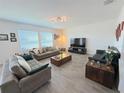 Spacious living room with comfy sofas, large TV, and wood-look flooring at 4390 Bull St, St Cloud, FL 34772
