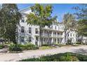Row of white townhouses with lush landscaping and a paved road at 4713 Anson Ln, Orlando, FL 32814