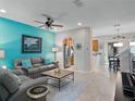 Bright living room with a colorful accent wall, comfortable seating, and tile flooring at 5381 Via Appia Way, Sanford, FL 32771