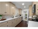 Well-lit kitchen featuring modern countertops, cabinetry, backsplash and a stainless steel dishwasher at 608 S Oxalis Ave, Orlando, FL 32807
