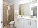 Bright bathroom features double vanity, modern lighting, and a glass-enclosed tiled shower at 7600 Mackinaw Ln, Kissimmee, FL 34747