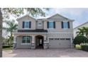 Charming two-story home featuring a brick driveway and a neutral color scheme with black shutters at 7600 Mackinaw Ln, Kissimmee, FL 34747