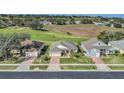 Aerial view of homes next to a golf course featuring mature trees and well-maintained landscaping at 1012 Everest St, Clermont, FL 34711