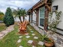 Landscaped side yard with stone pathway and rocking chairs at 124 Hollyhock Ct, Kissimmee, FL 34743