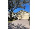 Attractive one-story home with a large tree and brick driveway at 124 Lancaster Dr, Davenport, FL 33897