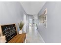 Inviting hallway featuring neutral paint, tile flooring and a view to the home's living spaces at 2214 Se Sawgrass Ct, Winter Haven, FL 33884