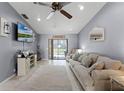 Comfortable living room with neutral walls, tile flooring, and sliding glass doors to the outside at 2214 Se Sawgrass Ct, Winter Haven, FL 33884