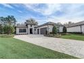 Home with two-car garage, manicured landscaping, brick accents, and tile roof at 25974 High Hampton Cir, Sorrento, FL 32776