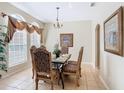 Elegant dining room with tile floors, large windows, and decorative chandelier at 2632 Sand Hill Point Cir, Davenport, FL 33837