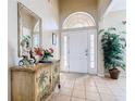 Inviting entryway with tiled floor, decorative palm tree cabinet and high ceilings at 2632 Sand Hill Point Cir, Davenport, FL 33837
