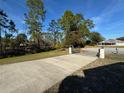 Long driveway leading to a gated property surrounded by lush trees at 2639 Janet Ct, Deltona, FL 32738