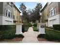 Community walkway with lush landscaping, leading to townhomes with neutral exteriors at 5405 Napoli Cv, Lake Mary, FL 32746