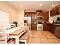 Bright kitchen with stainless steel appliances, tiled floor, wooden cabinets and dining table at 5405 Napoli Cv, Lake Mary, FL 32746