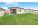 Spacious backyard with lush green grass, a screened-in patio, and a privacy fence at 651 Tortugas St, Haines City, FL 33844