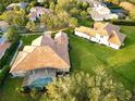 Aerial view of a large home featuring a screened pool area, clay tile roof, and spacious green yard at 6533 Cartmel Ln, Windermere, FL 34786