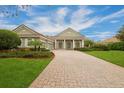 Elegant home featuring a large driveway, manicured lawn and landscaping at 6533 Cartmel Ln, Windermere, FL 34786