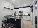 Modern kitchen with stainless steel appliances, granite countertops, and ample cabinet space at 17438 Promenade Dr, Clermont, FL 34711