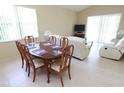 Open dining room with a glass-top table, comfortable seating for six, and sliding door access to outdoors at 1809 Wedgewood Way, Kissimmee, FL 34746