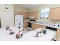 Functional kitchen with light wood cabinets, white appliances, and ample counter space for cooking and meal prep at 1809 Wedgewood Way, Kissimmee, FL 34746