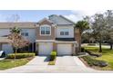 Inviting townhome featuring a two-car garage, neutral colors, and manicured landscaping at 2011 Stockton Dr, Sanford, FL 32771