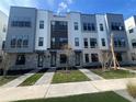 Three-story townhouses with gray and white exterior, landscaping, and walkway at 2221 Valentine Aly, Orlando, FL 32804