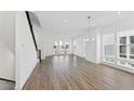 Open concept living room with hardwood floors, large windows and modern chandelier at 2221 Valentine Aly, Orlando, FL 32804