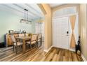Bright dining area featuring modern light fixture, wood-look floors, and convenient front door access at 2351 Fenton Ave, Clermont, FL 34711