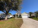 Charming single-story home featuring a well-manicured lawn, mature trees, and a two-car garage at 2351 Fenton Ave, Clermont, FL 34711