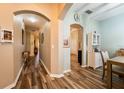 Inviting hallway with warm wood-look floors and elegant archways leading to dining area and living spaces at 2351 Fenton Ave, Clermont, FL 34711